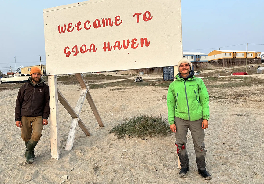 the two guys next to a town sign